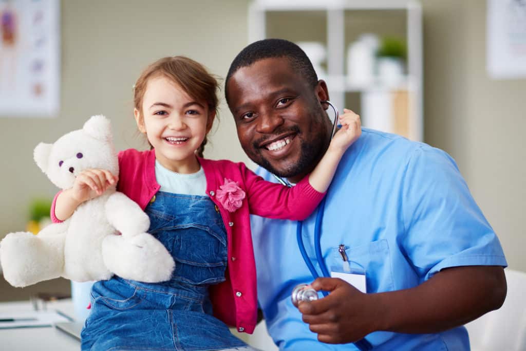 Portrait of a cute little girl and her doctor at hospital